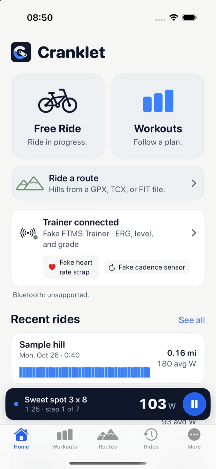 The Home screen: two big tiles, Free Ride and Workouts, a wide Ride a route tile under them, a card saying the trainer, a heart rate strap, and a cadence sensor are connected, recent rides with their power traces, and a slate bar at the bottom with the running workout, 1:25, and 103 watts.
